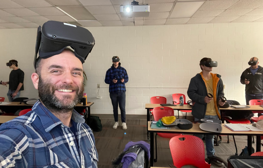 Photo of Professor Jesse Hampton using virtual reality with students in the classroom. 