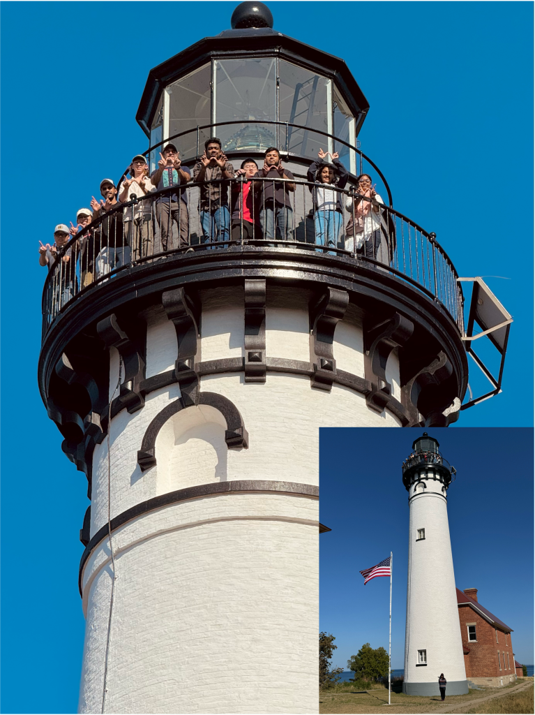 Photo of people standing on top of a lighthouse.